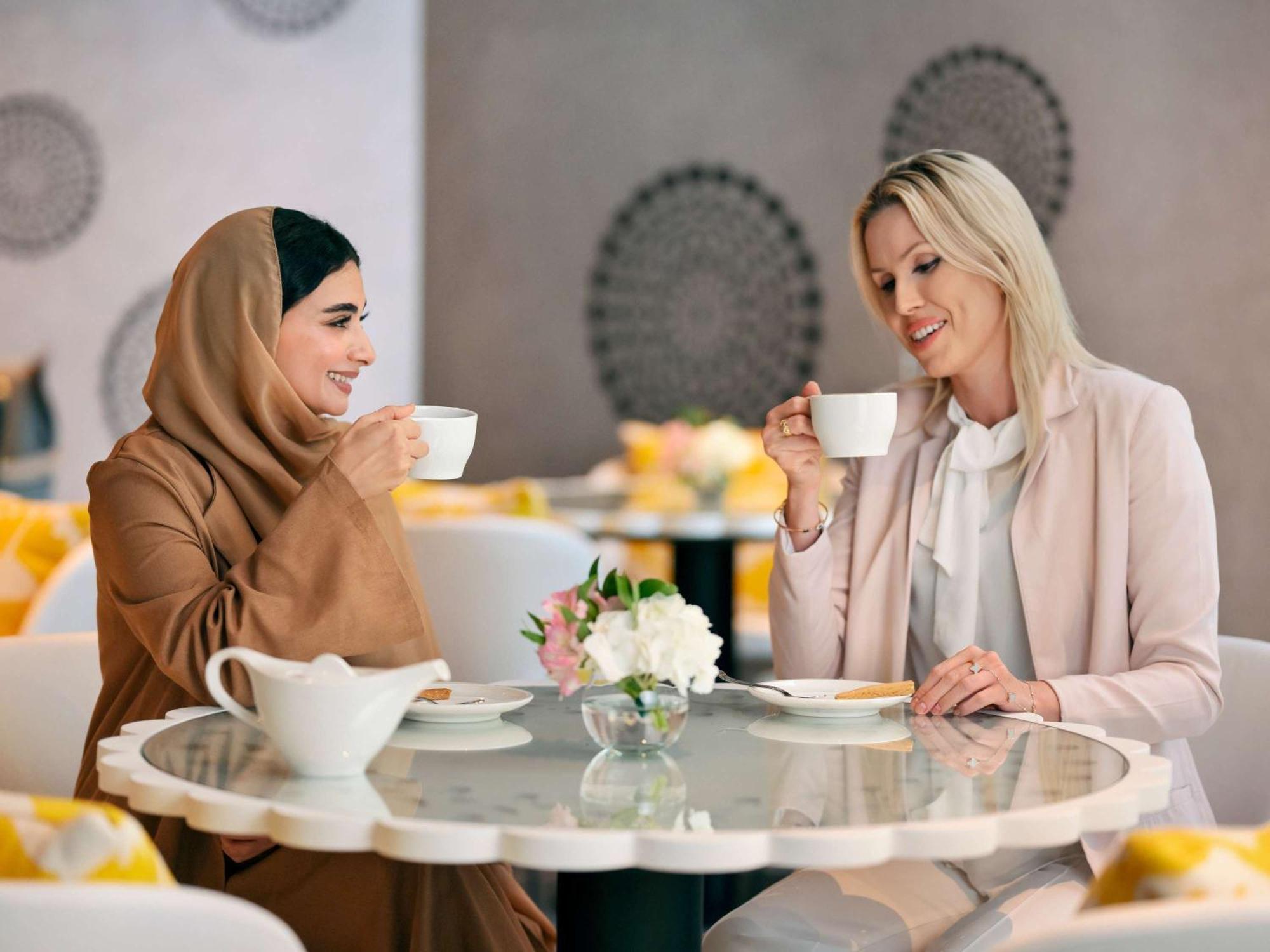Moevenpick Hotel & Apartments Ghala مسقط المظهر الخارجي الصورة Two women drinking coffee